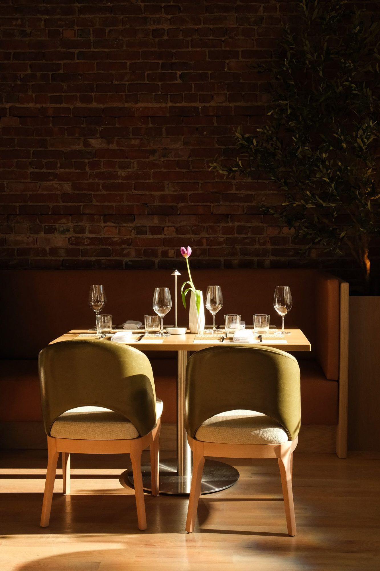 A table for two set with wine glasses and a single tulip in the Clementina dining room